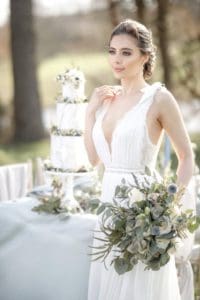 An elegant bride with wedding cake in the background