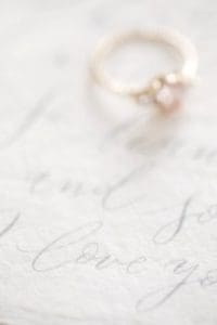 engagement ring on top of a wedding note