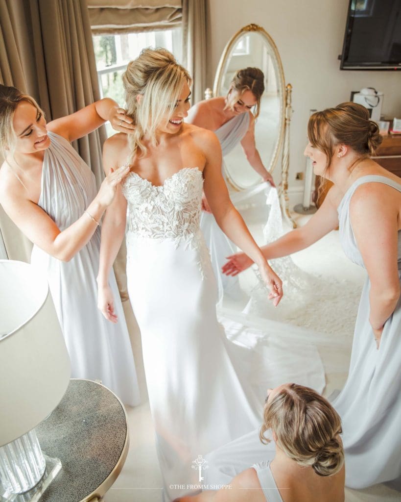 Bridesmaids assisting bride