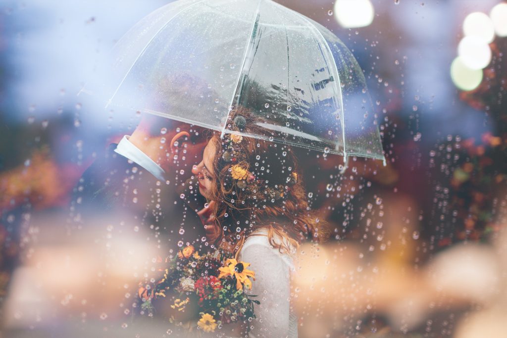 wedding couple underneath an umbrella