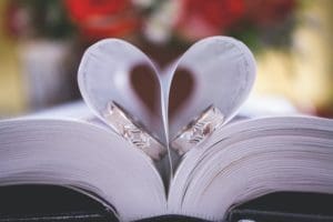 Wedding rings and book page with a heart